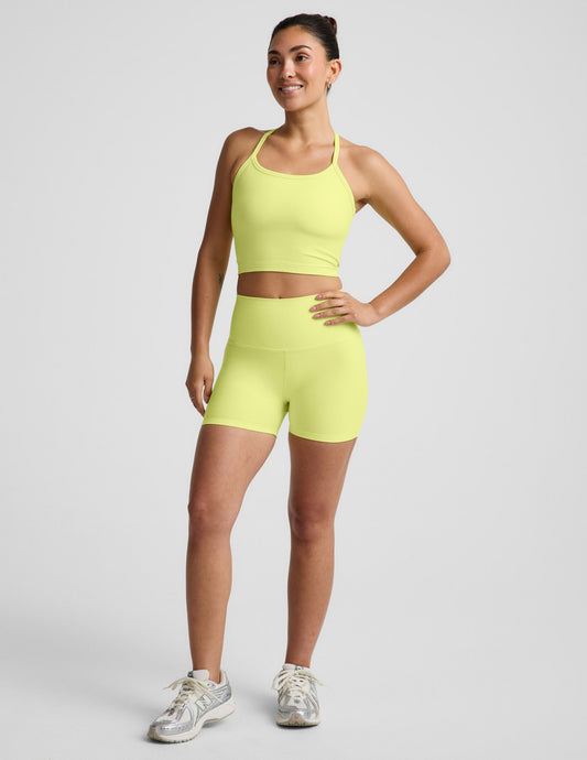 Woman wearing Yellow Spacedye™ Keep Pace 3" Short with high waistband, paired with a matching tank and white sneakers.