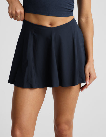 Woman wearing Navy You're A force Skirt™ with a V-shaped waistline, paired with a matching navy cropped tank top.