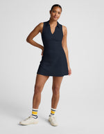 Woman wearing a sleeveless mini athletic dress against a plain background.