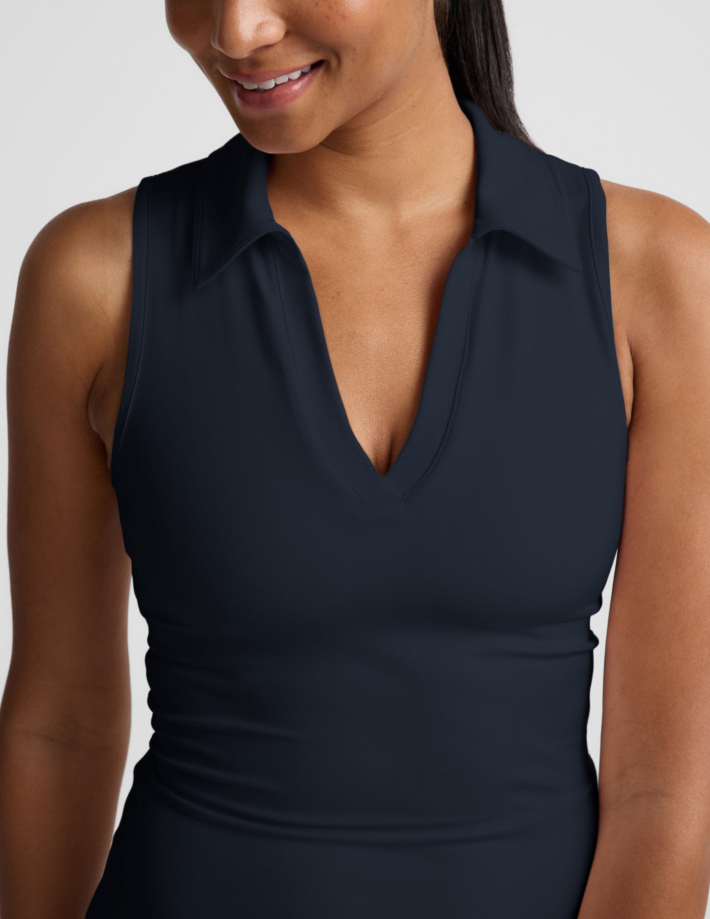 Woman wearing a sleeveless mini athletic dress against a plain background.