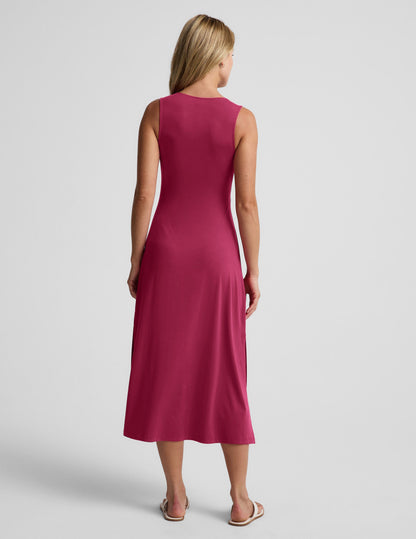 Woman wearing a red midi tank dress with a front center cutover against a light gray background.