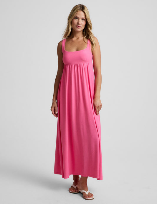 Woman wearing a pink maxi dress on a plain background.