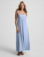 Woman wearing a light blue maxi dress on a plain background.