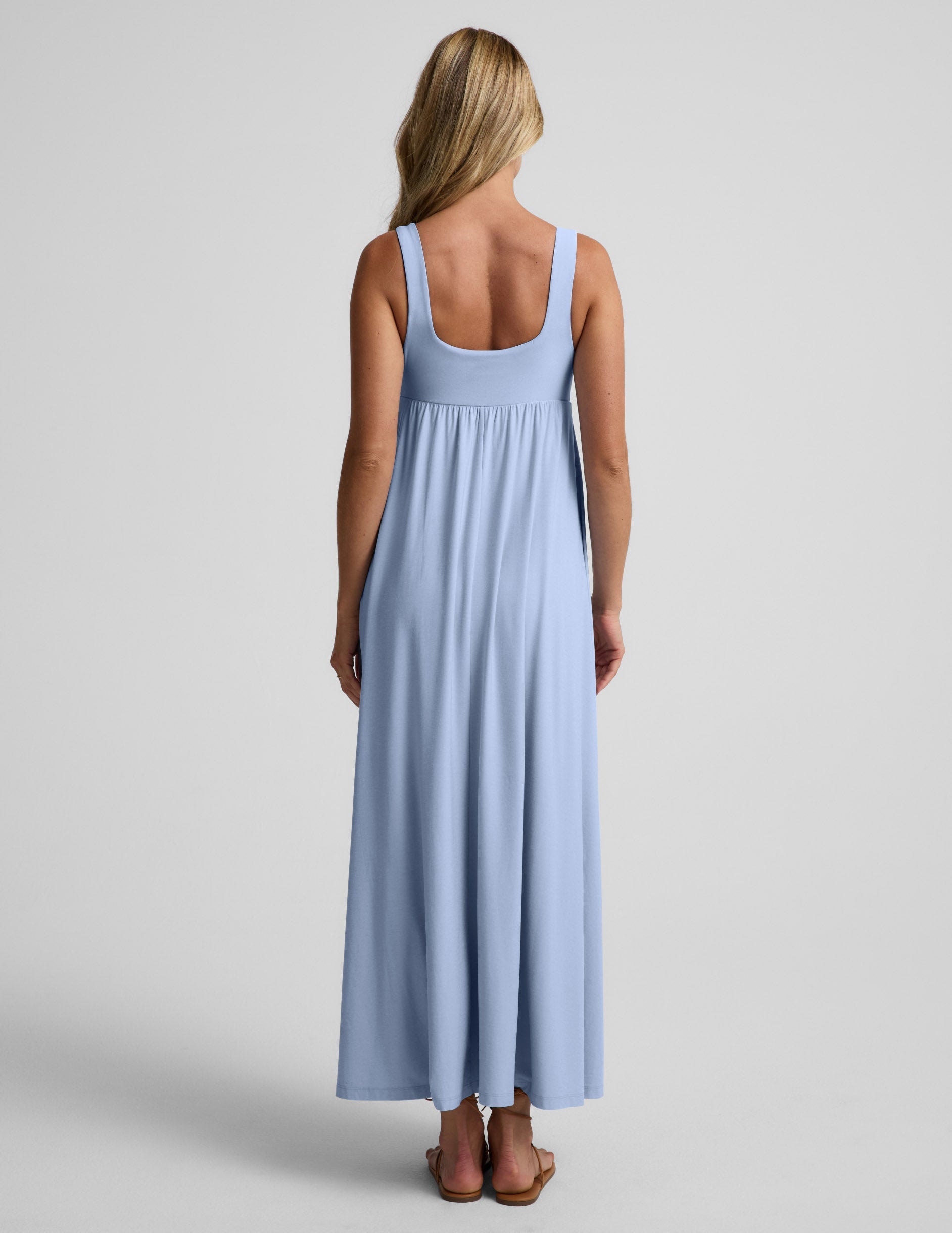Woman wearing a light blue maxi dress on a plain background.
