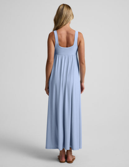 Woman wearing a light blue maxi dress on a plain background.