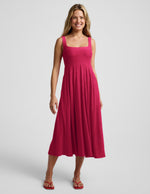 Woman wearing a red square neck tank midi dress on a plain background.