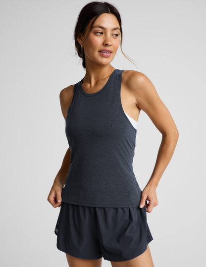 Woman wearing a blue active racerback tank and blue run shorts against a plain background.