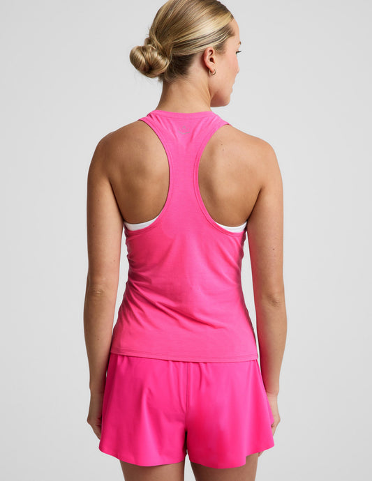 Woman wearing a pink tank top and pink running shorts against a plain background.