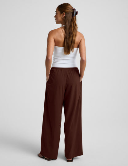 Woman wearing Brown Solstice™ Drawstring Wide Leg Pant 29" with a white tube top, Rear view.