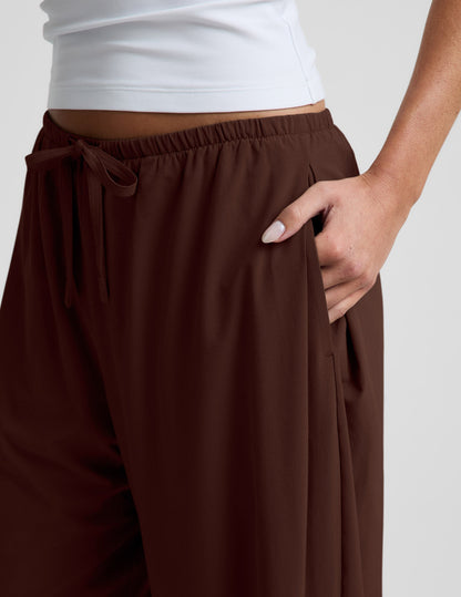 Close-up of woman wearing Brown Solstice™ Drawstring Wide Leg Pant 29" with hand in side pocket and white top.