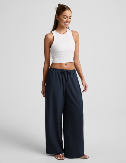 Woman wearing Navy Solstice™ Drawstring Wide Leg Pant 29" paired with a white ribbed cropped tank top.