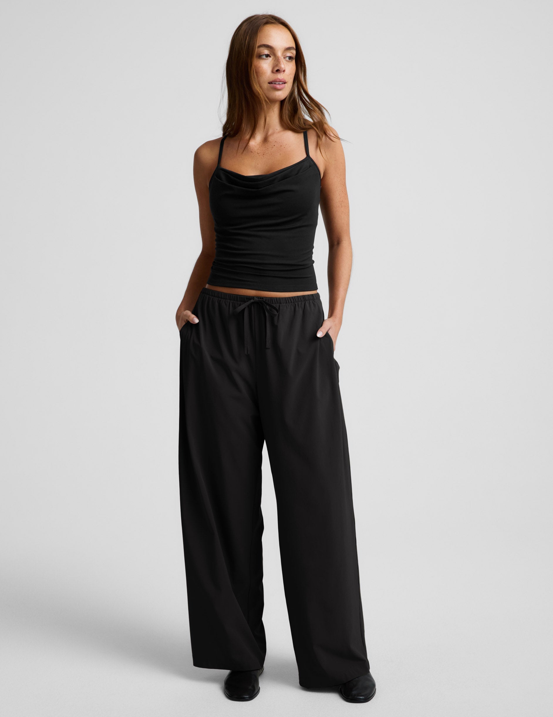 Woman wearing black Solstice™ Drawstring Wide Leg Pant 31" paired with a black cowl-neck camisole.