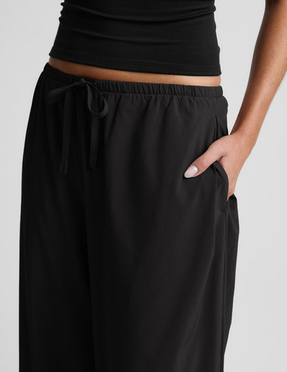 Woman wearing black Solstice™ Drawstring Wide Leg Pant 31" with a drawstring waist, paired with a black cropped top.