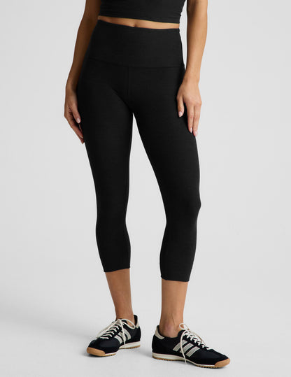 Woman wearing Black Spacedye™ Walk And Talk High Waisted Capri Legging paired with a black crop top and sneakers.