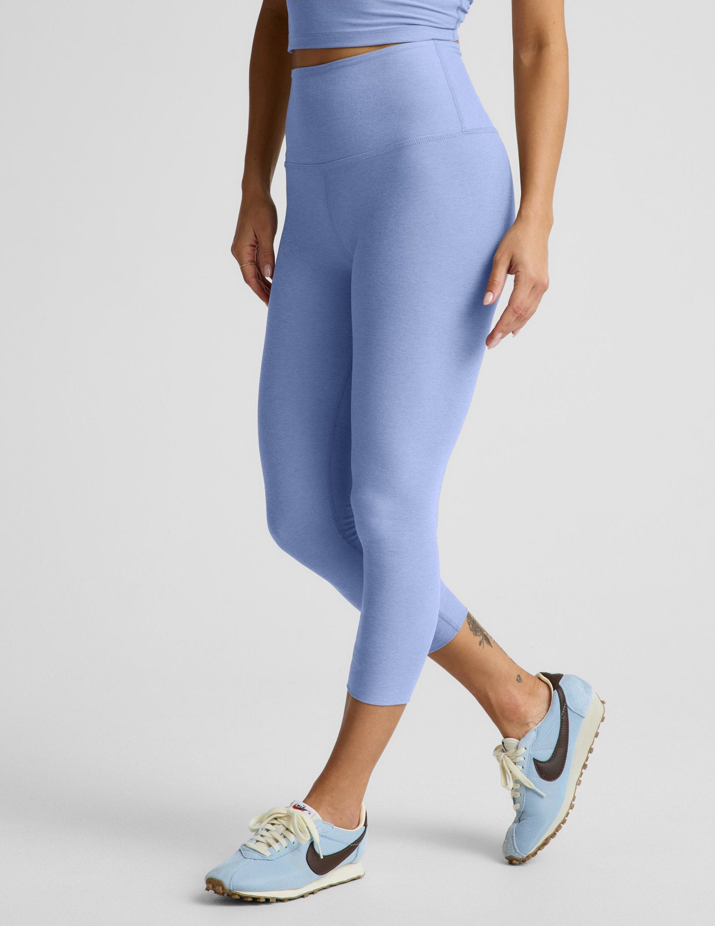 Woman wearing Ice-Blue Spacedye Walk And Talk High Waisted Capri Legging paired with a matching crop top and sneakers.
