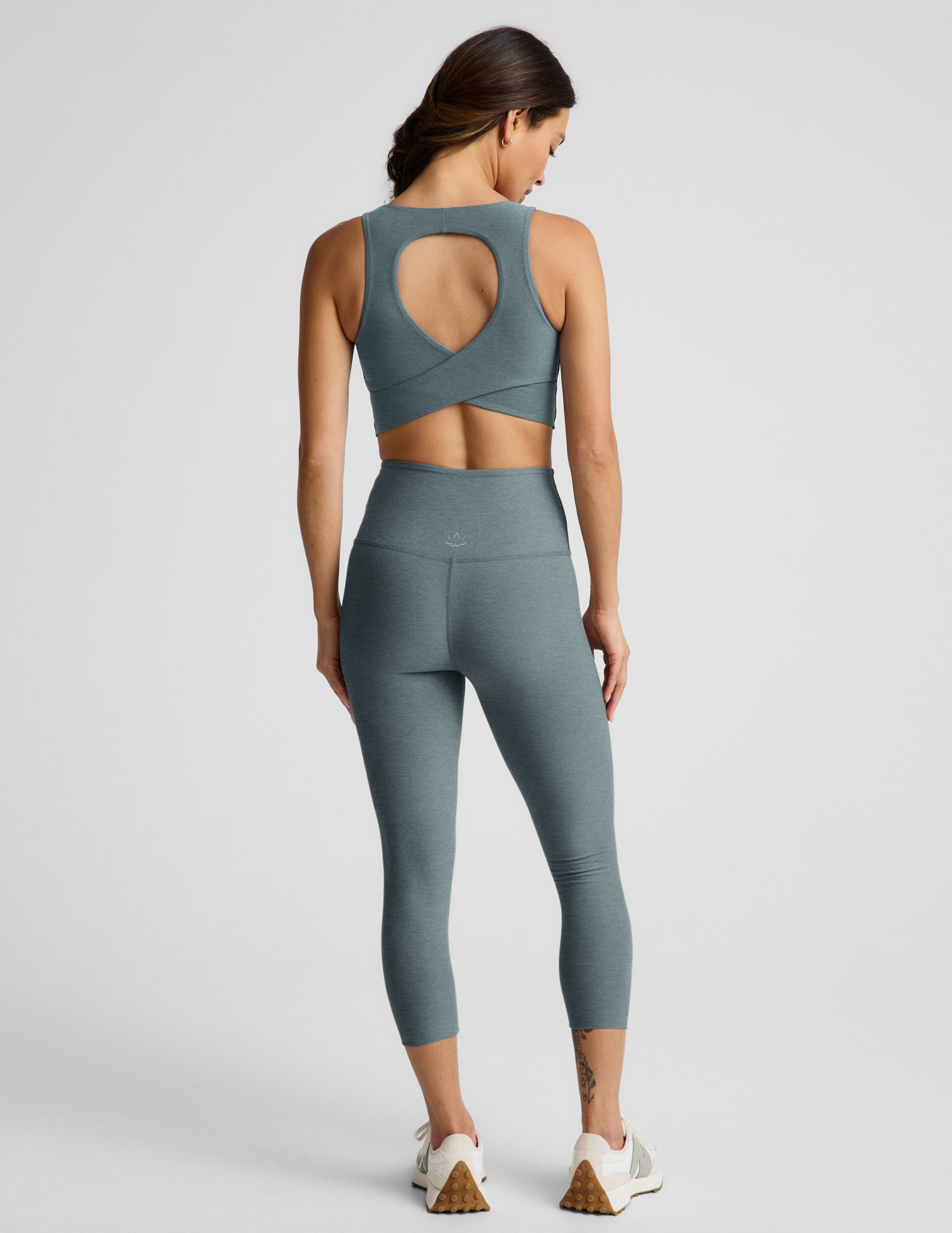 Woman wearing Green Spacedye Walk And Talk High Waisted Capri Legging™ with a matching crop top, Rear view.
