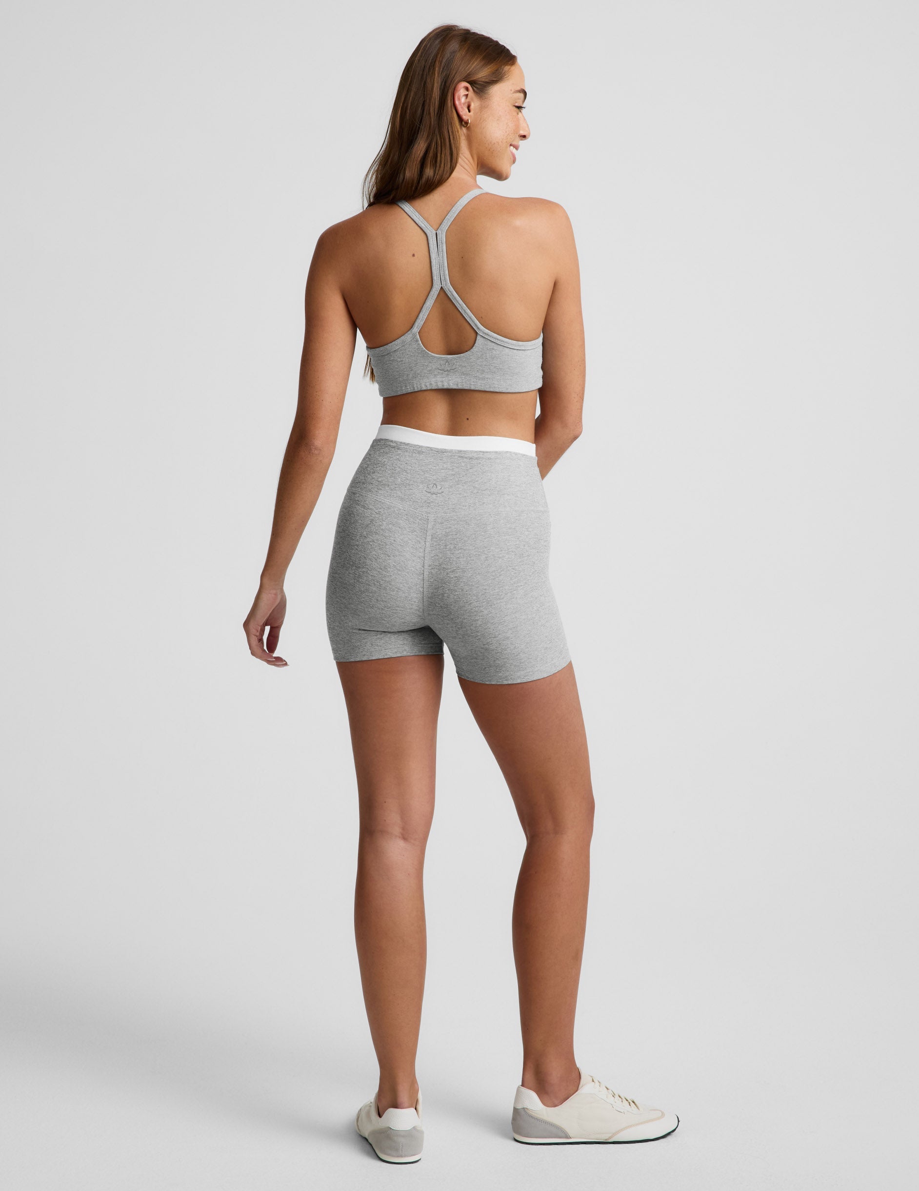 Woman wearing Gray Spacedye™ Layered 3" Short, rear view, paired with a matching sports bra and white sneakers.