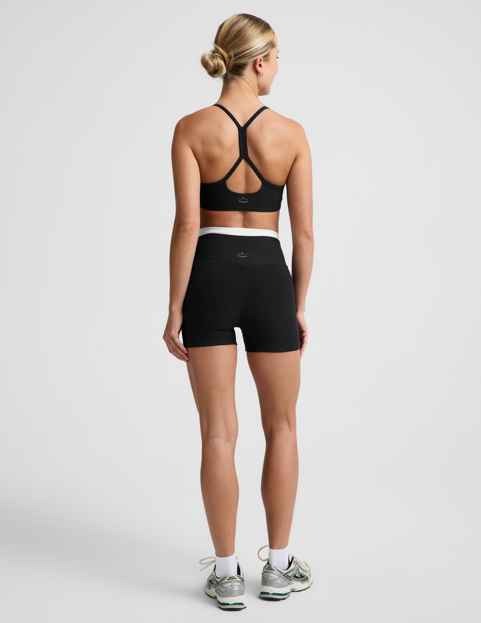 Woman wearing Black Spacedye™ Layered 3" Short, rear view, paired with a black sports bra and white sneakers.