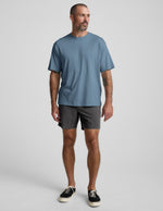 Front view of a man wearing the dark gray Saturday Men's Short, featuring an elastic waistband and straight mid-thigh fit.