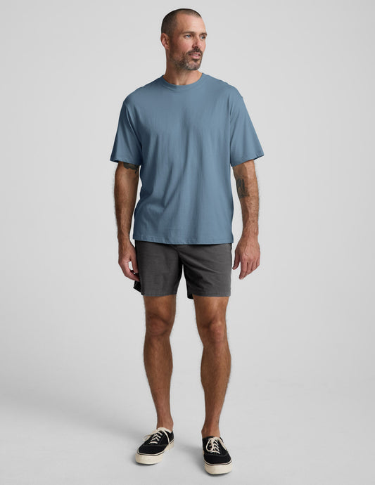 Front view of a man wearing the dark gray Saturday Men's Short, featuring an elastic waistband and straight mid-thigh fit.