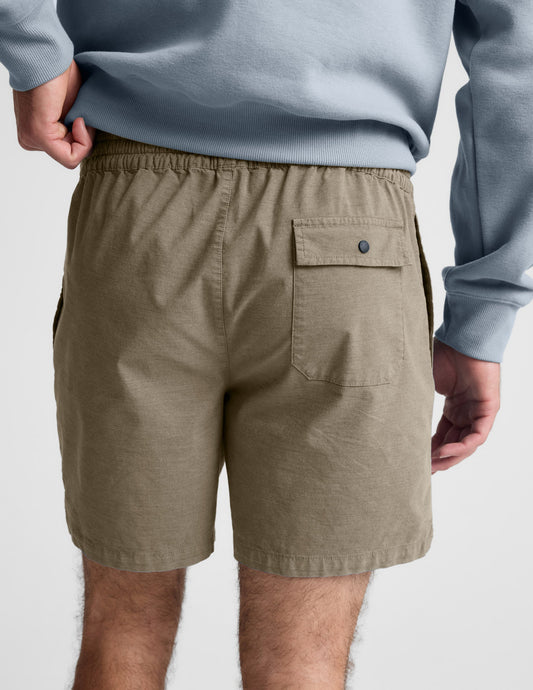 Back view of olive Saturday Men's Short showing the elastic waistband and a back patch pocket with a snap closure.