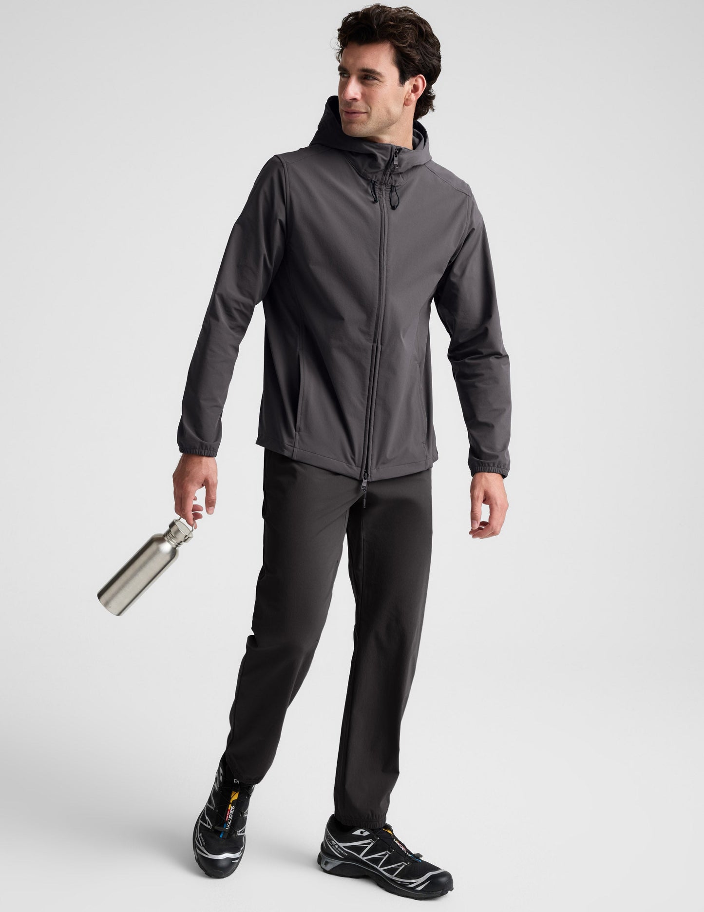 Man wearing a gray hooded jacket on a light gray background.