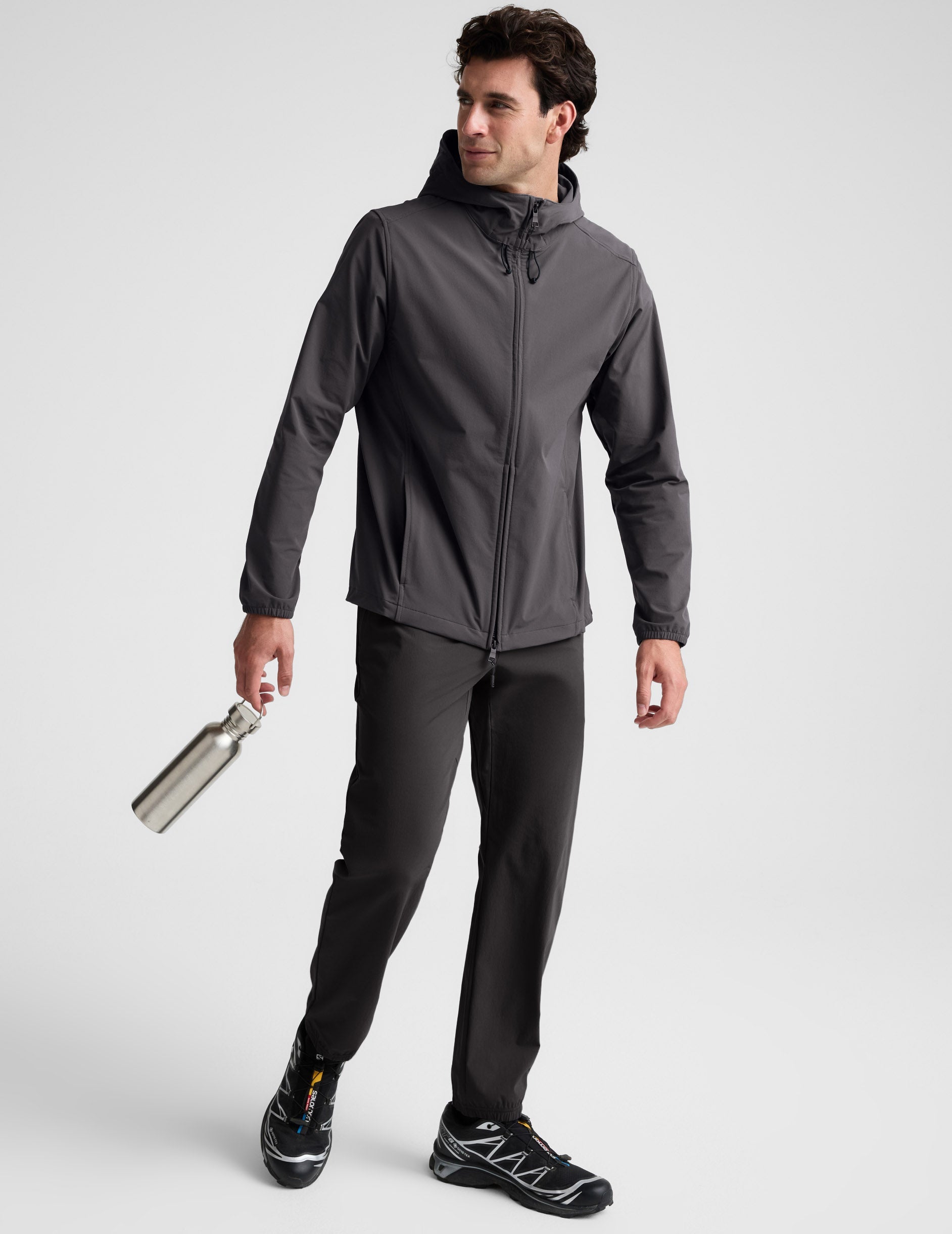 Man wearing a gray hooded jacket on a light gray background.