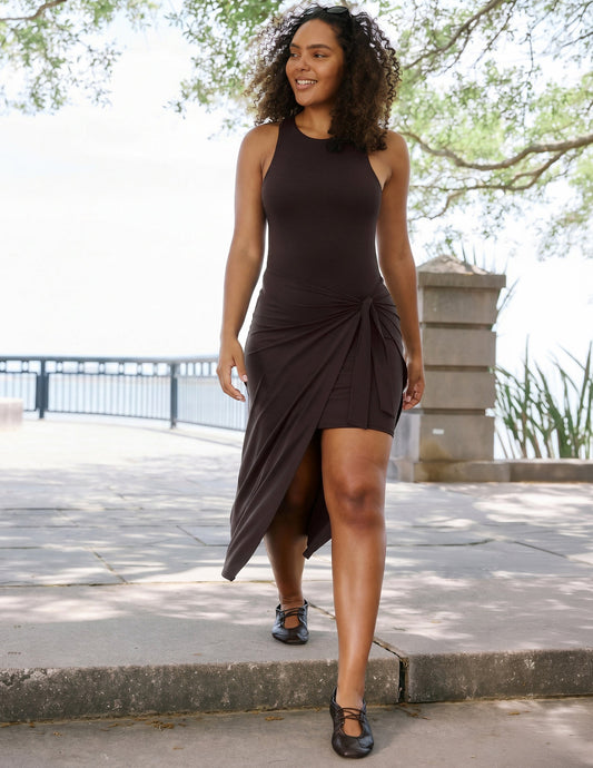 Woman wearing a brown midi length wrap dress.