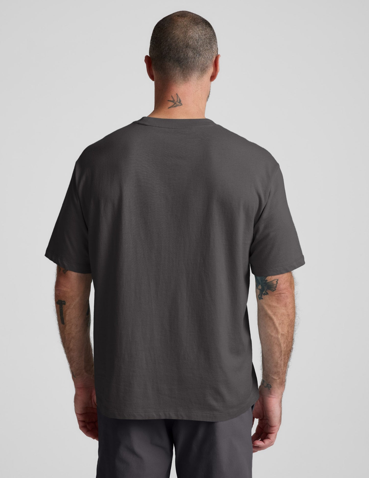 Man wearing a black cotton tee and pants against a plain background.