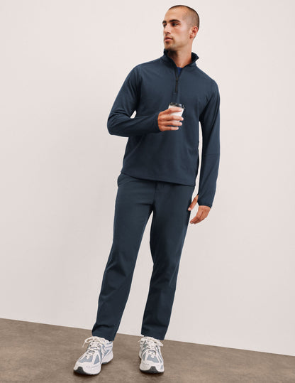 Man stands in Navy Dynamic Men's Straight Leg Pant, featuring a relaxed fit, paired with a matching top and white sneakers.
