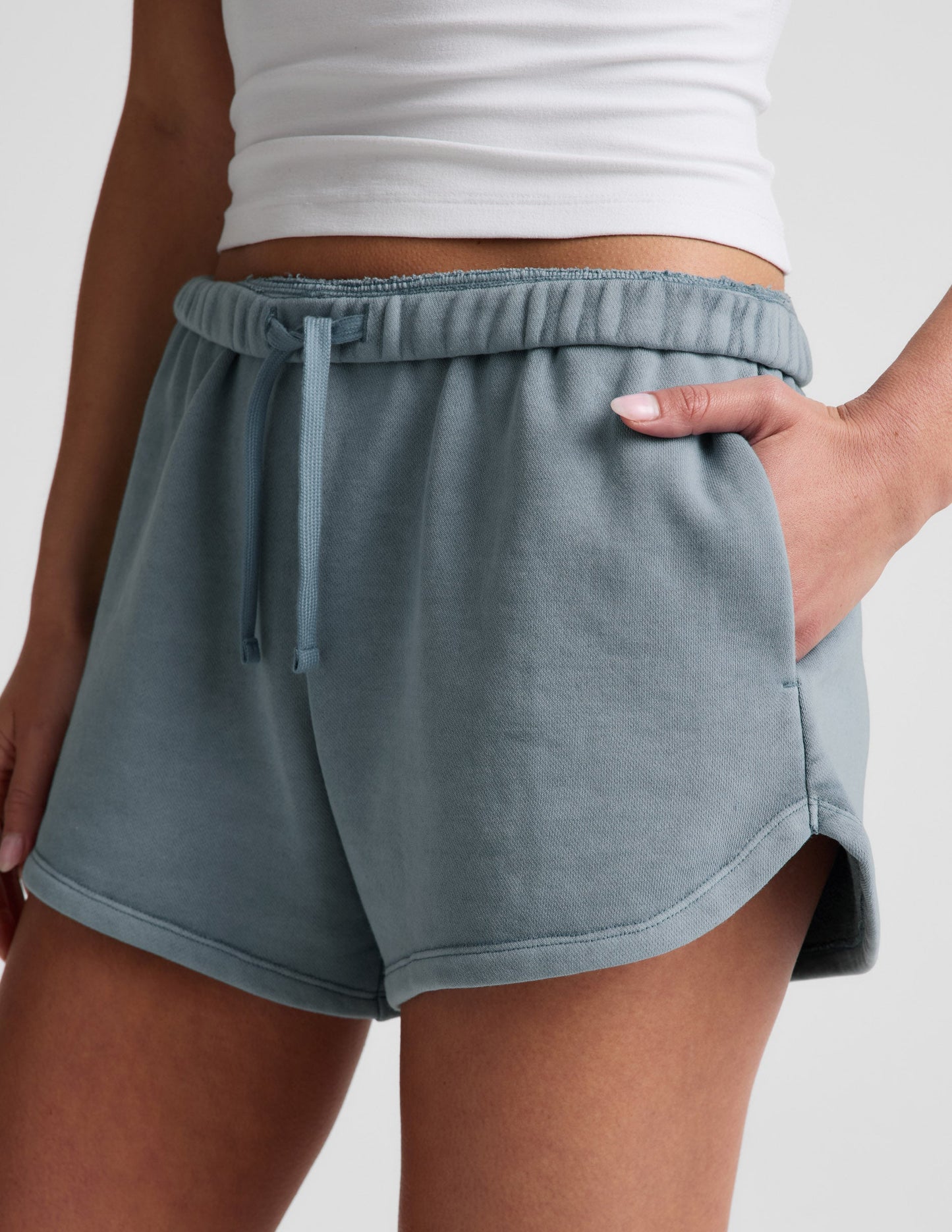 Capri blue Fade Out Mid-Rise Short with an adjustable drawstring waistband, side pockets, and a curved dolphin-style hem.