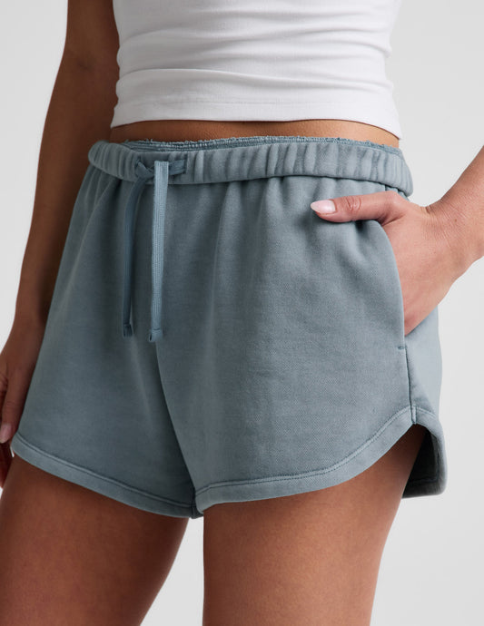 Capri blue Fade Out Mid-Rise Short with an adjustable drawstring waistband, side pockets, and a curved dolphin-style hem.