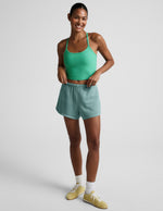 Turquoise Fade Out Mid-Rise Short on a smiling model, featuring a gathered elastic waistband and curved dolphin hem.