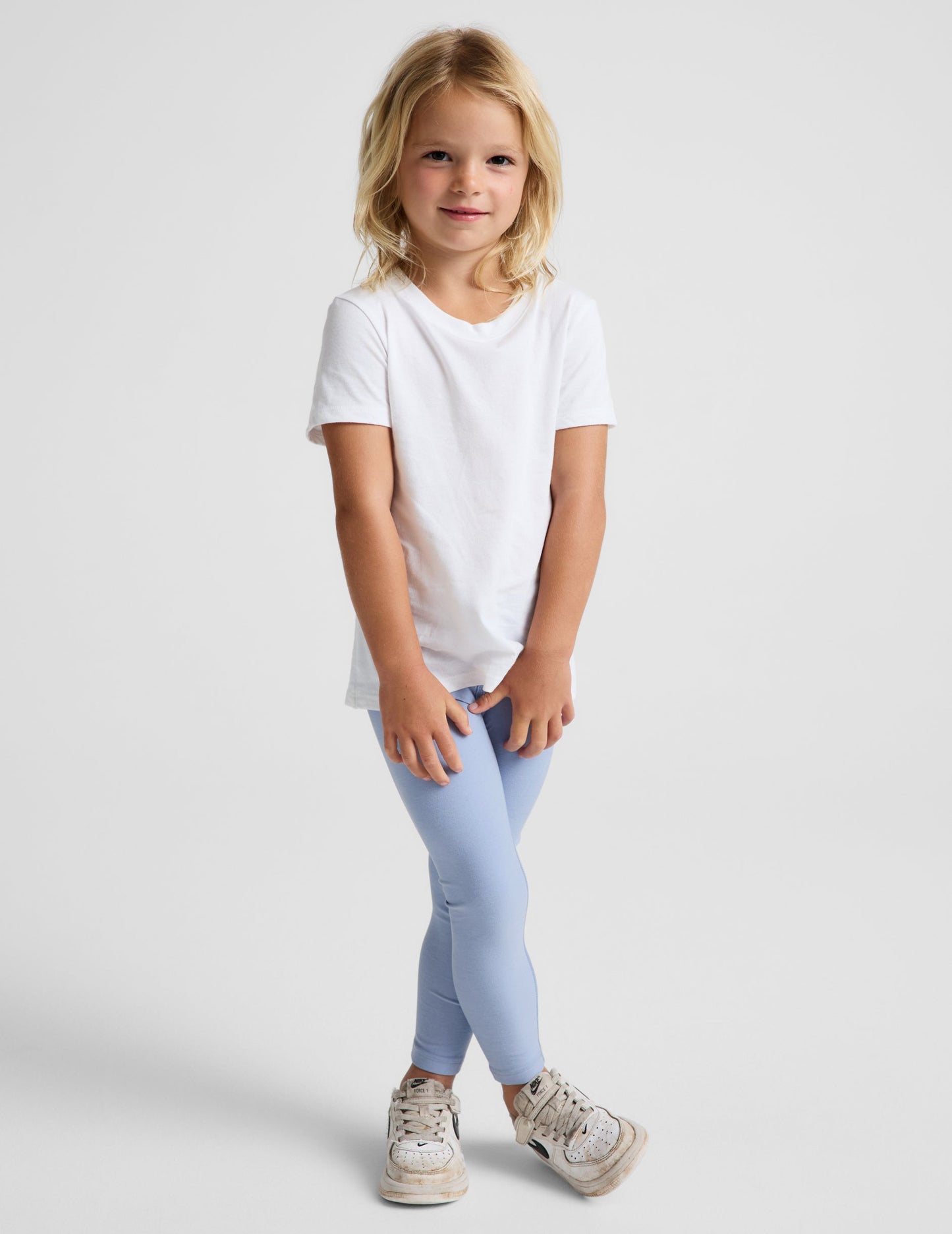 Girl wearing Blue Spacedye™ Toddler Legging with a white t-shirt and sneakers.