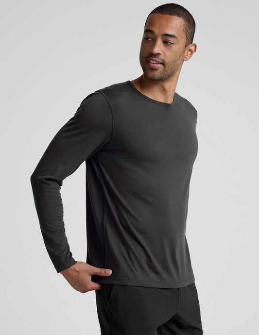 man wearing a black long-sleeve shirt against a plain background.