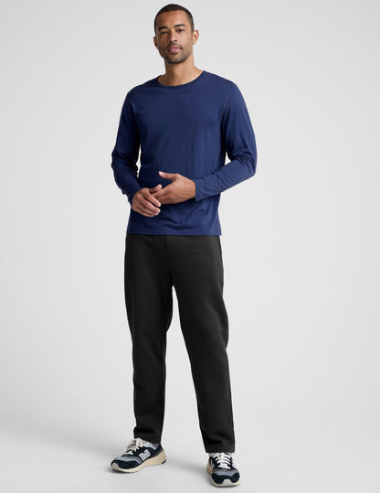 man wearing a blue long-sleeve shirt against a plain background.