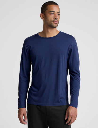 man wearing a blue long-sleeve shirt against a plain background.