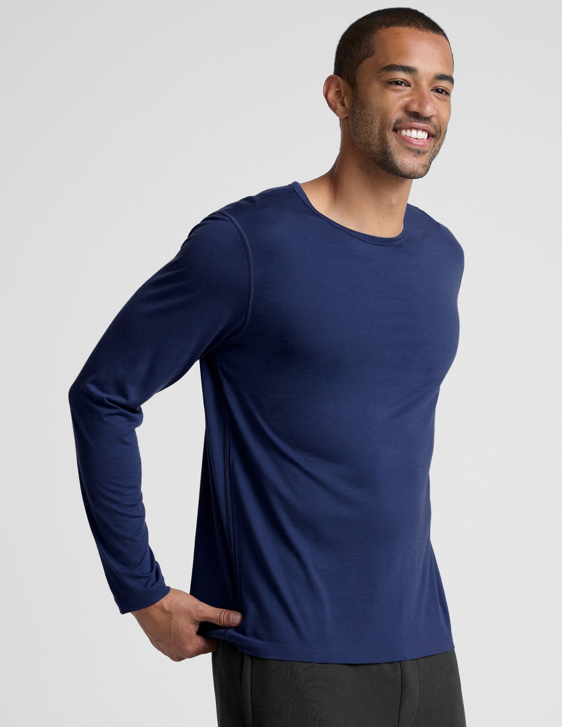 man wearing a blue long-sleeve shirt against a plain background.