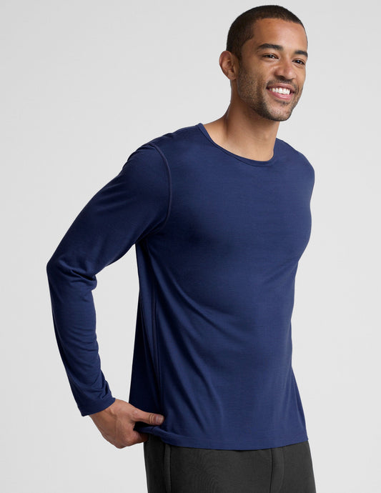 man wearing a blue long-sleeve shirt against a plain background.