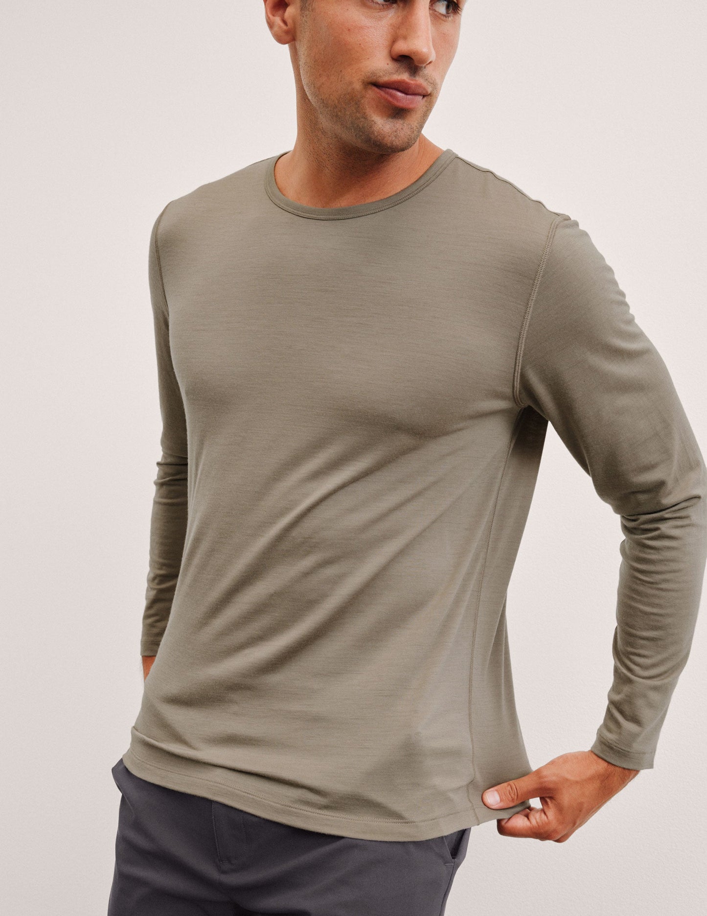 Man wearing a brown long-sleeve shirt against a plain background.