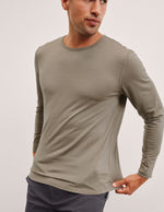 Man wearing a brown long-sleeve shirt against a plain background.