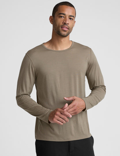 Man wearing a brown long-sleeve shirt against a plain background.