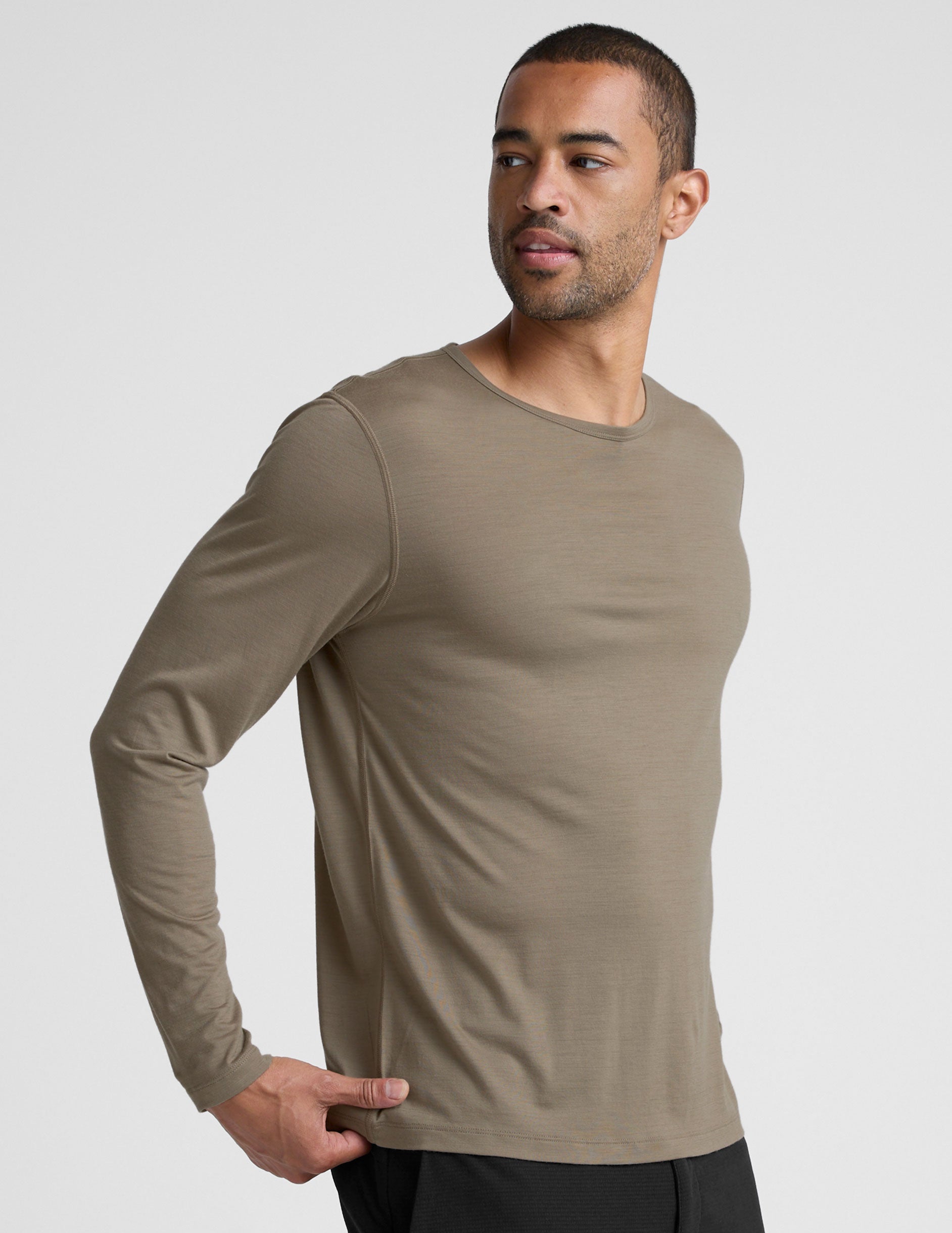 Man wearing a brown long-sleeve shirt against a plain background.