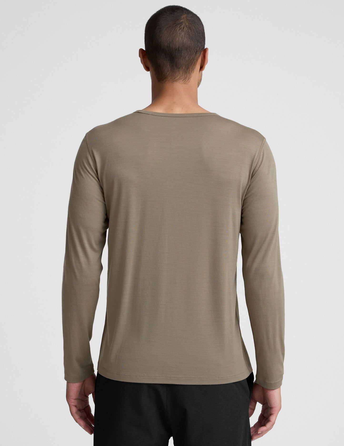 Man wearing a brown long-sleeve shirt against a plain background.