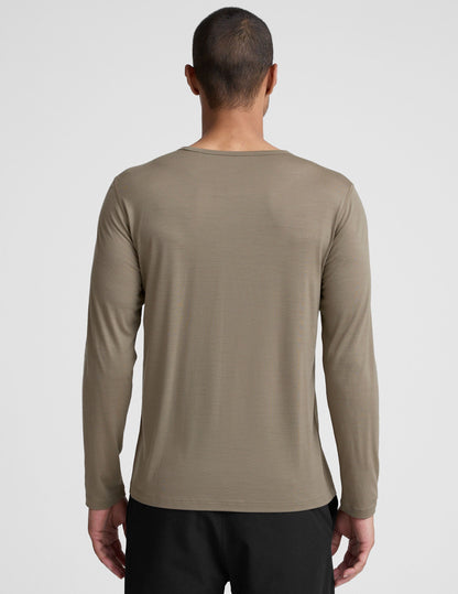 Man wearing a brown long-sleeve shirt against a plain background.
