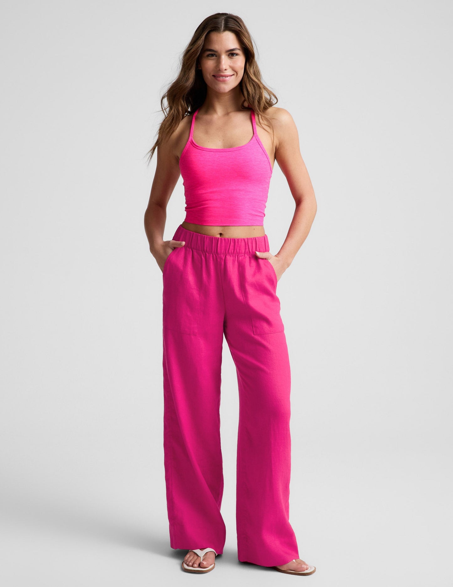 Model wearing Fuchsia SoftWash Linen Easy Wide Leg Pants with a gathered waistband, front pockets, and a matching tank top.