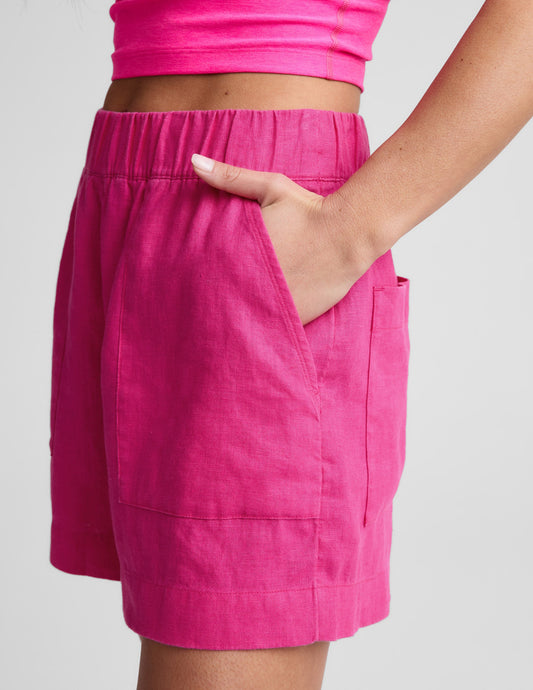 Side view of fuchsia SoftWash Linen Easy Short with an elastic waistband and hand in the front slant pocket.