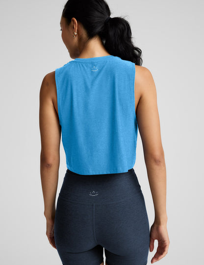 Woman wearing a light blue sleeveless top and biker shorts against a plain background.