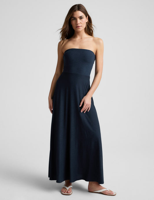 Woman wearing a strapless navy blue maxi dress on a light gray background.