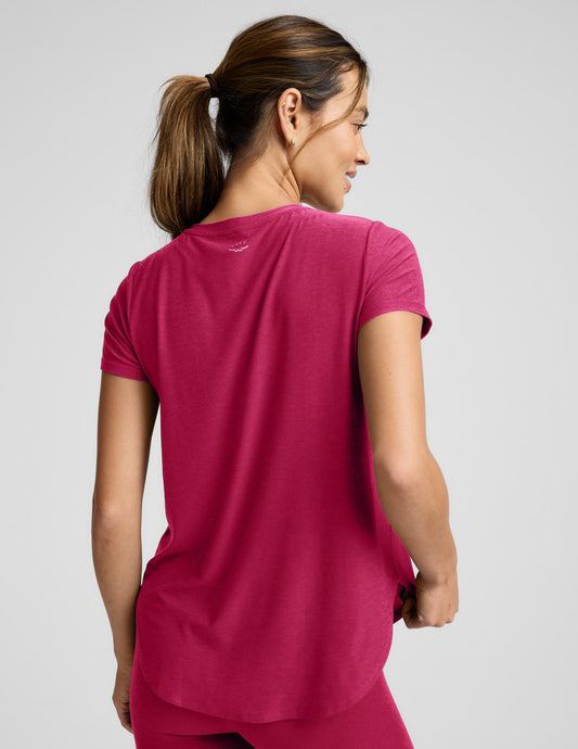 Woman wearing a red t-shirt and red leggings against a plain background.